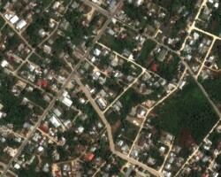 A satellite image of the homes and buildings in Tonga before a volcano erupted.
Satellite image ©2022 Maxar Technologies